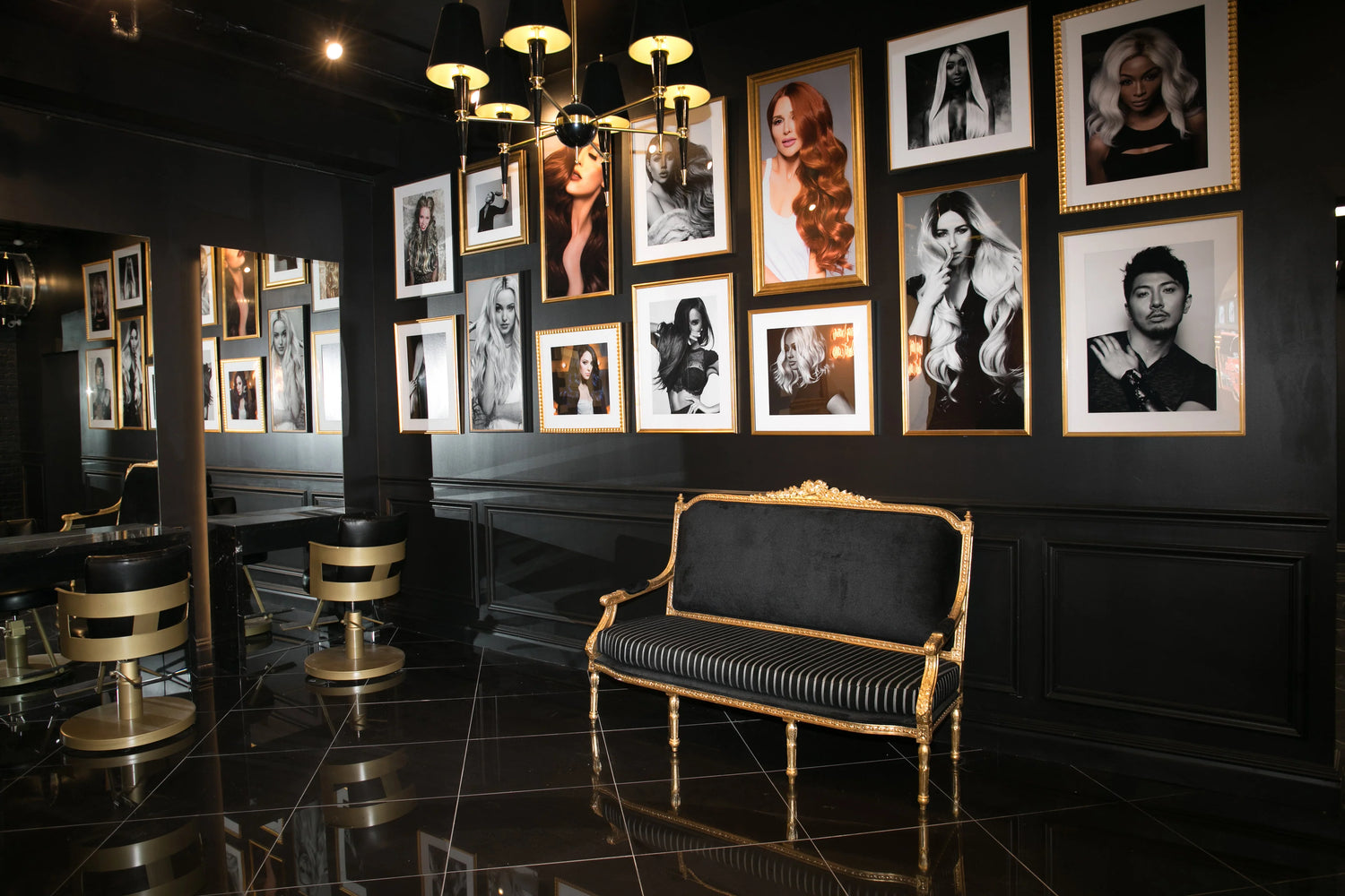 Black and gold salon interior with framed portraits, a gold-accented couch, and stylish chairs on a glossy floor.