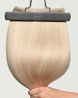 BELLAMI Flex Weft 2.0 hair extensions in Champagne Bubbles™ (#P10/16/60-80), a trademarked BELLAMI hair color from the Eric Vaughn collection with a multi-tonal highlight blend, fanned into a rounded silhouette beneath the hanger clip.